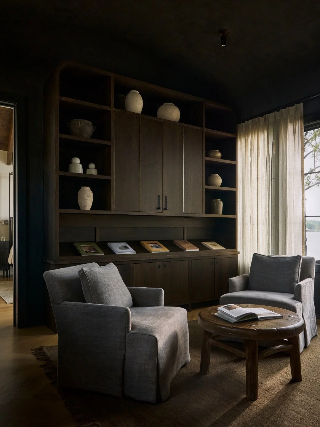 What could have been just a hallway became one of our favorite spaces in this project. 

In our Wicker Point project on Lake Martin, the master passthrough became an opportunity to create something unexpected&mdash;a dramatic, moody sitting room that