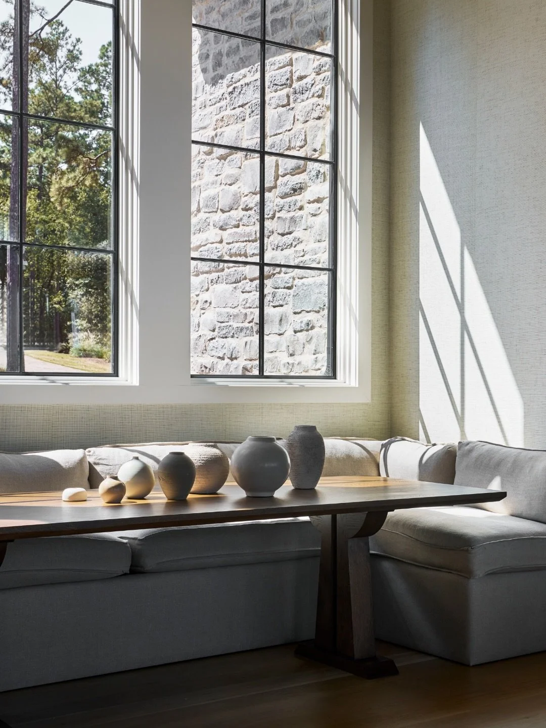 The entryway at our Wicker Point project is more than a passage &mdash; it&rsquo;s an experience in itself. A generous banquette dining area welcomes you in, framed by black windows that ground the space and draw the eye outward. Above, rich wood bea