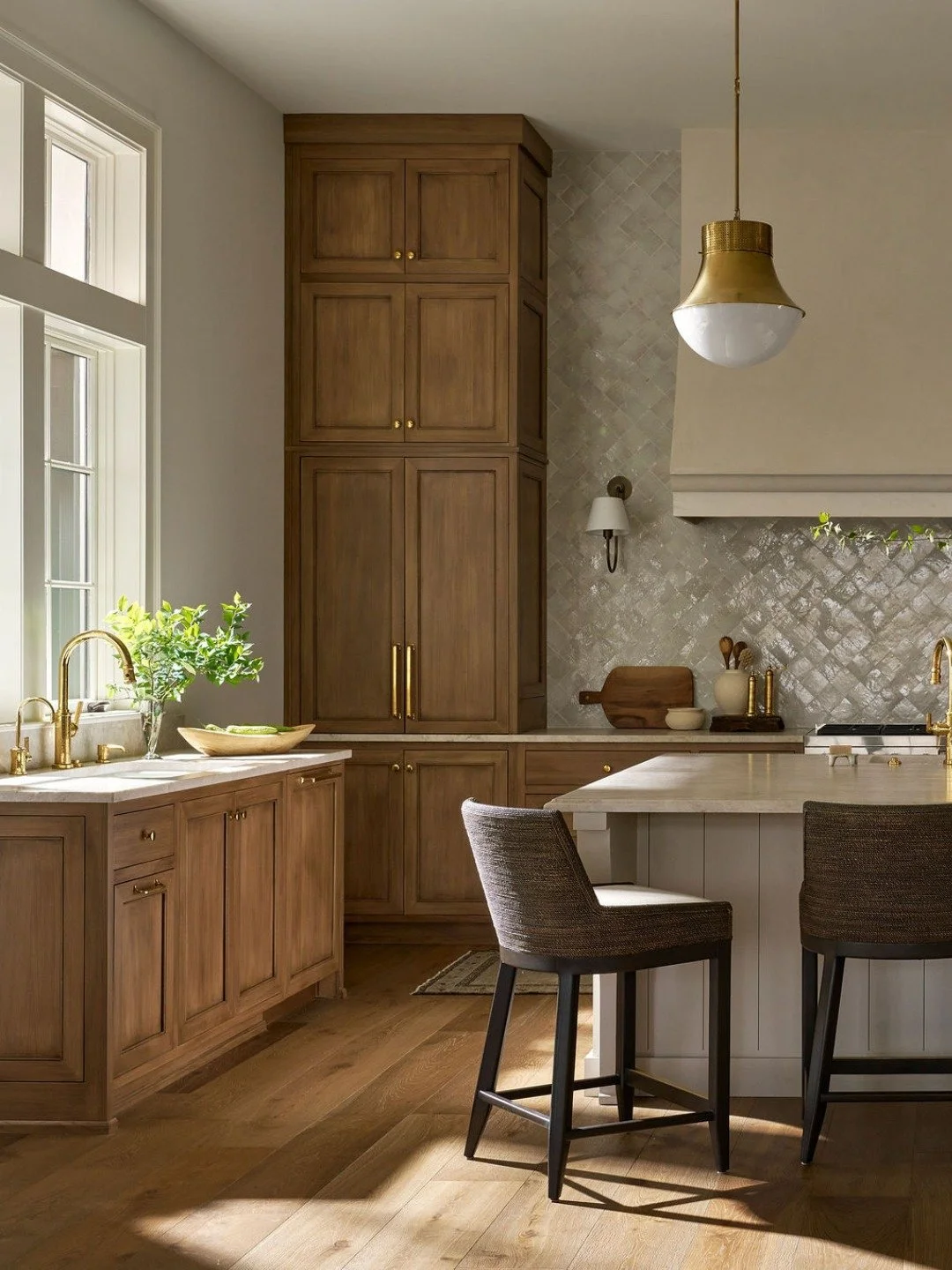 Elevated neutrals, done the Krywicki way. 🤍

The kitchen in our Cuscowilla project layers warmth and texture through glossy zellige tile, rich wood cabinetry, soft quartzite countertops, and an oversized plaster range hood that quietly steals the sh