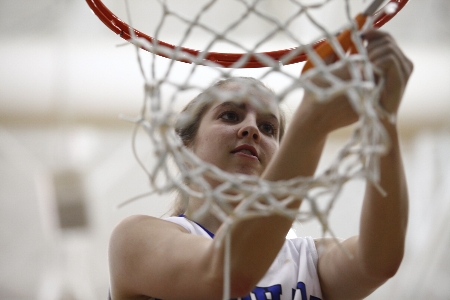 Oldham County junior Kasey Wernert cuts down the basketball net after the Lady Colonels 50-43 win over the Lady Dragons in the District 29 Girls Basketball Tournament in Goshen.