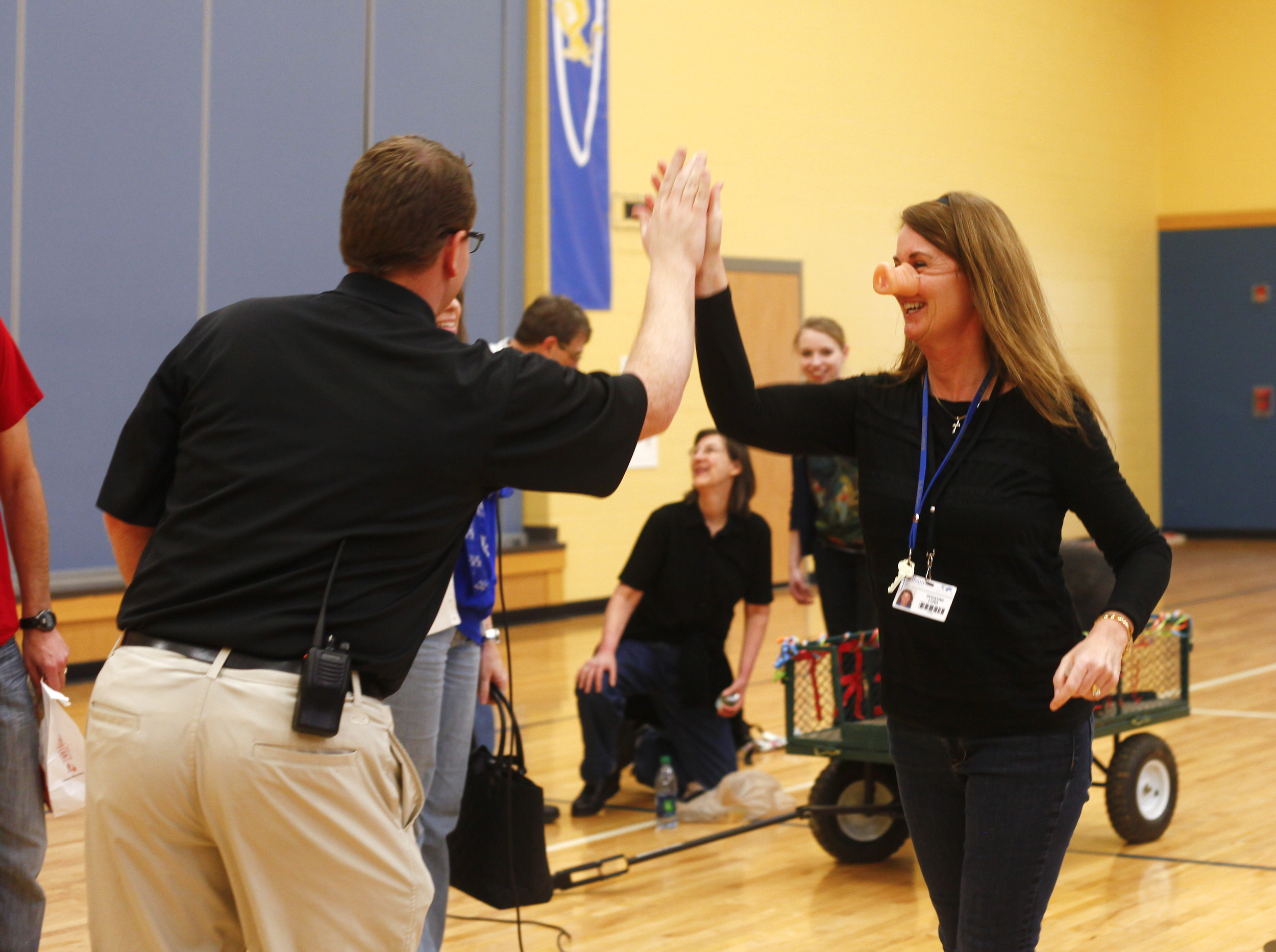 Third grade teacher Roxanne Lund high fives Principal Andy Moore after being called down to kiss Herbert the pig.
