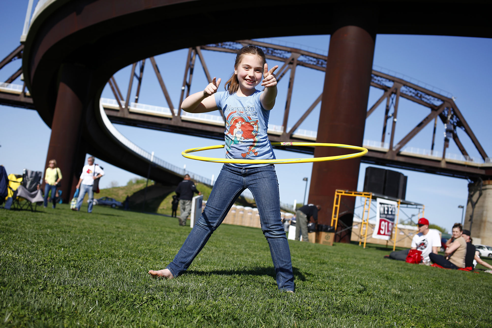 Charlotte Glaab, 8 of Louisville, hula-hoops in front of the Big Four Bridge before the start of the first Waterfront Wednesday of the summer.