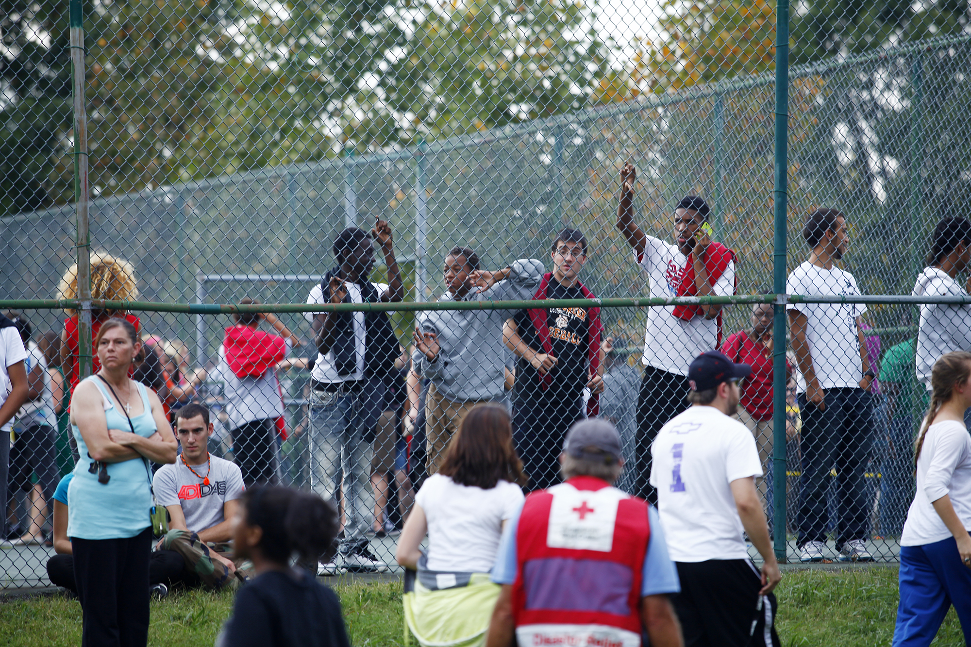 Students wait for their parents to pick them up from the tennis court after a student at Fern Creek High School shot another student.