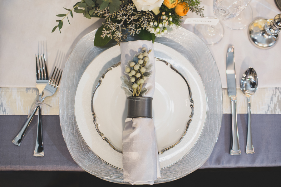 I am SO obsessed with this place setting. Metal, leather tied forks, a little sparkle, lots of linens, a unique place card idea, and super for flowers.love. 