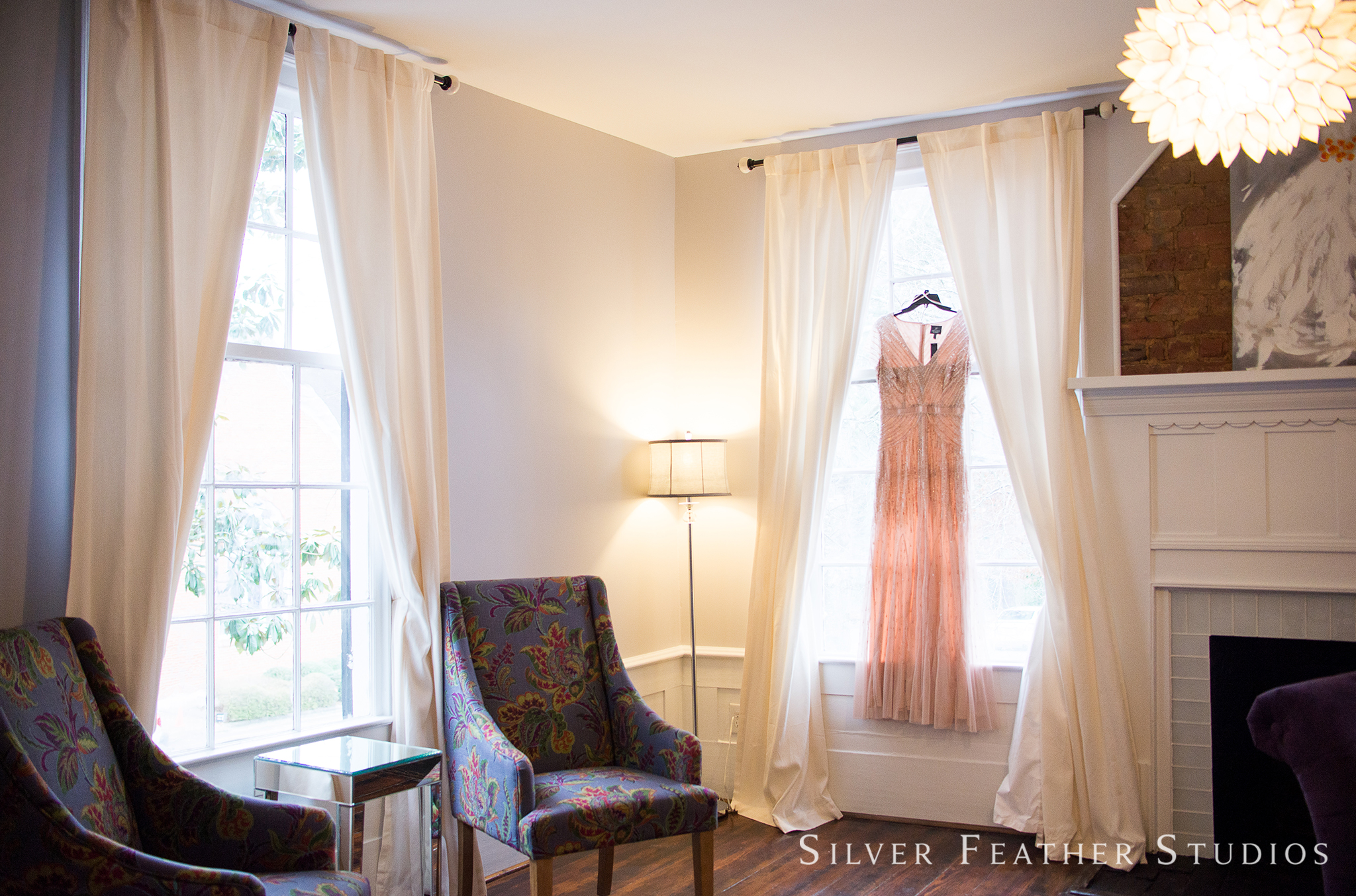 Pink gown hangs from window at this holly springs wedding venue. Raleigh wedding photographer, Silver Feather Studios.