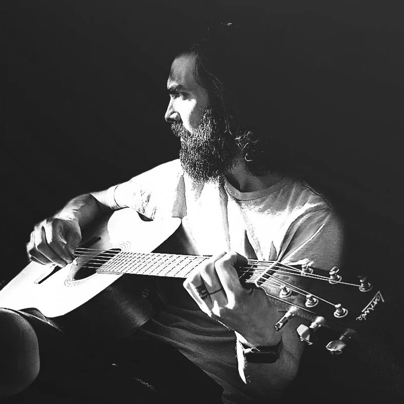 Brian Bustos playing the acoustic guitar.