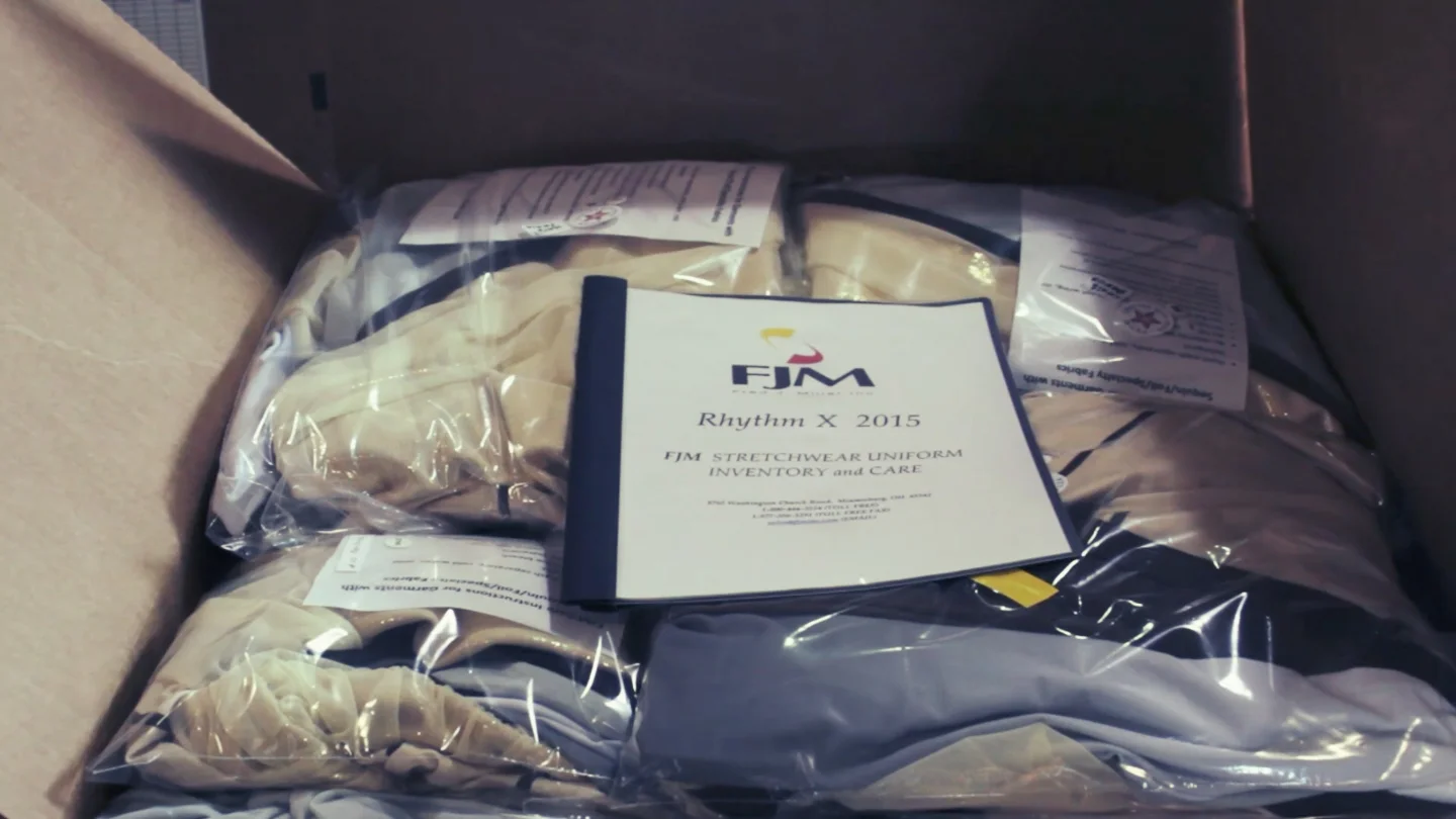 The completed uniforms are packaged with care and fit instructions, ready for pick-up by Rhythm X, Inc.!