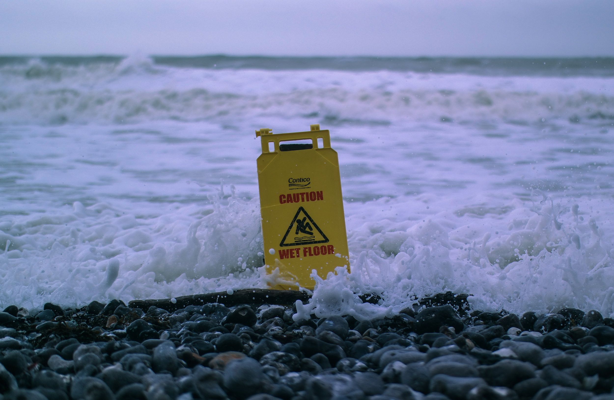 Caution wet floor a-frame sign in the surf.