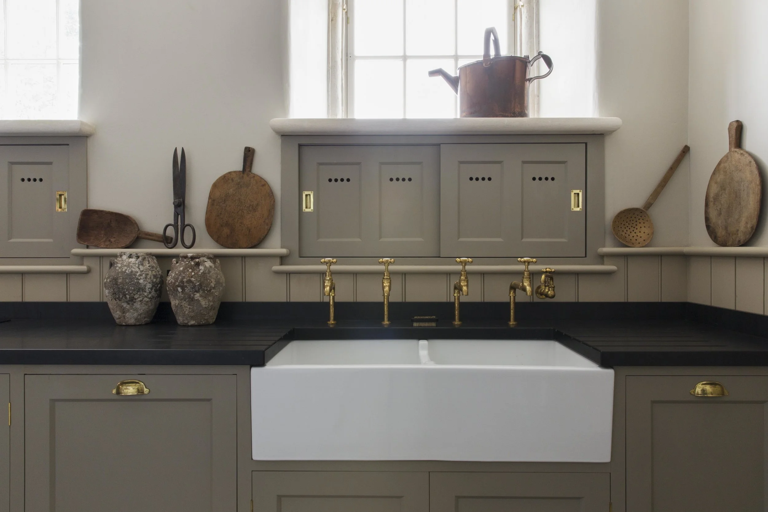 Antique accessories sit perfectly next to the ceramic sink and brass taps.