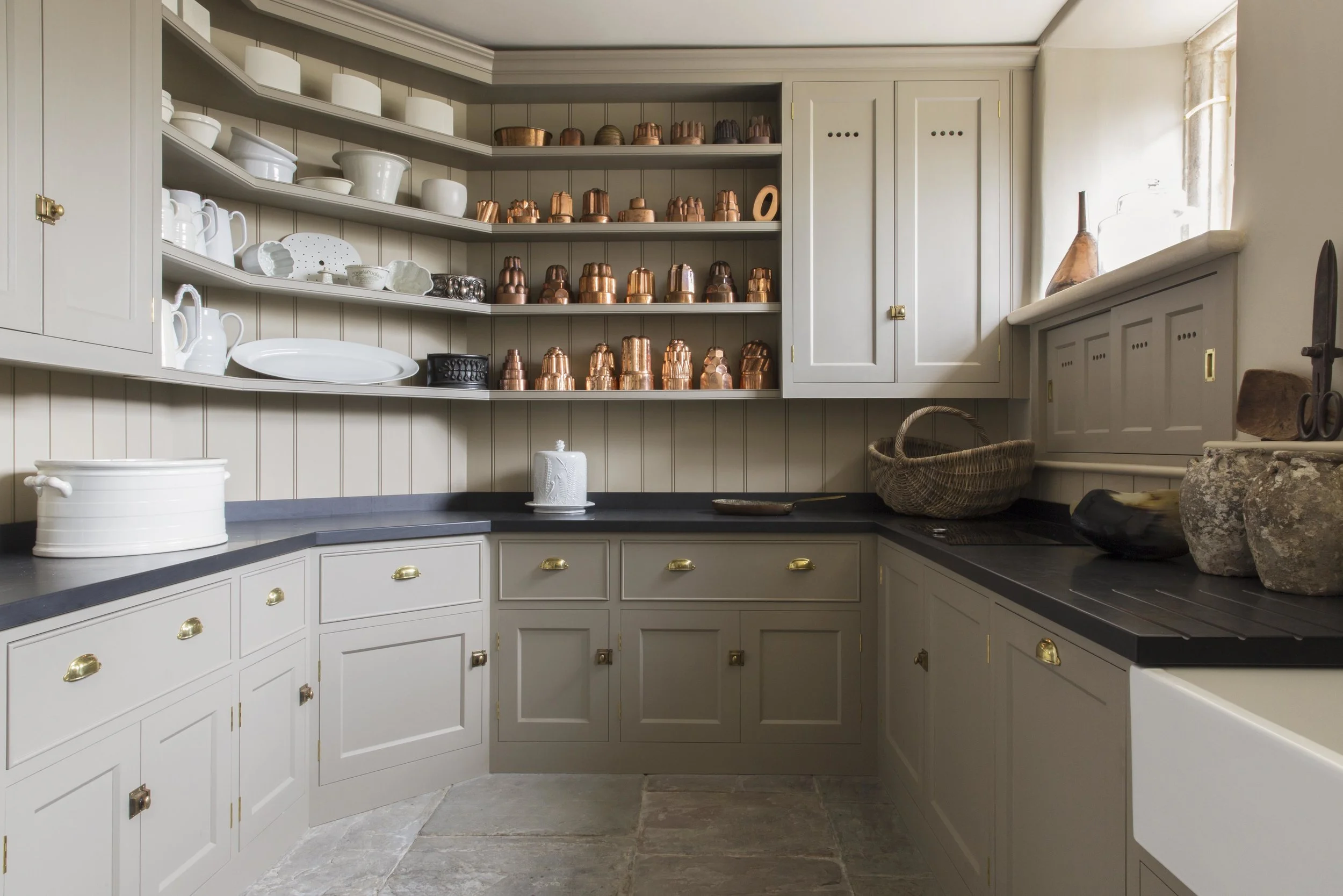 The natural tones of the paintwork and large York stone slabs act as a wonderful foil for this impressive collection of jelly moulds.