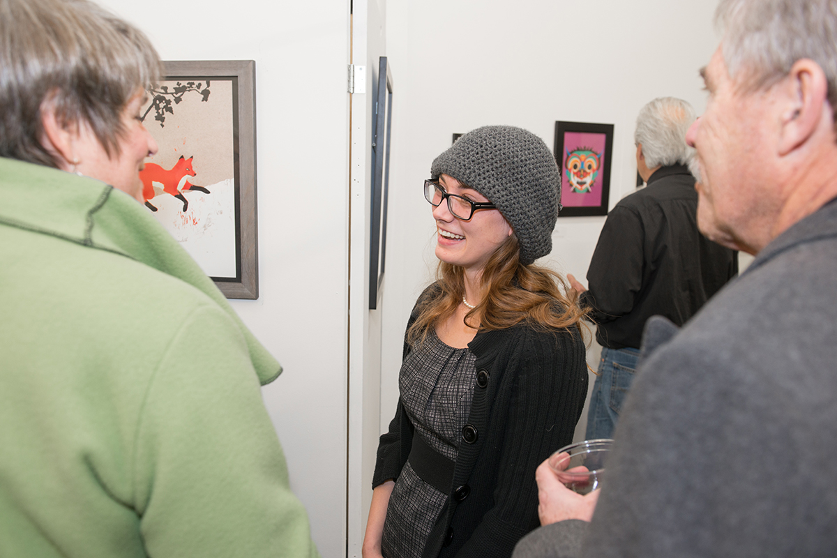 Junior Rosie Ruzicka talking about her piece with patrons Cindy and Steve Kunz.