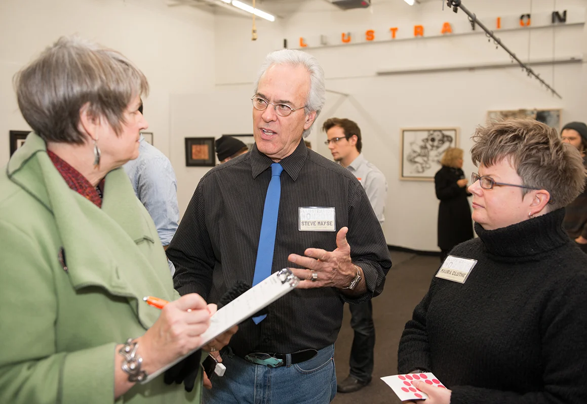 Professor and Department Chair Steve Mayse talking with patron Cindy Kunz about the show. (That's me, prof Maura Cluthe, on the right ready with some red dots. I was more than happy to place red dots on some pieces that night!)