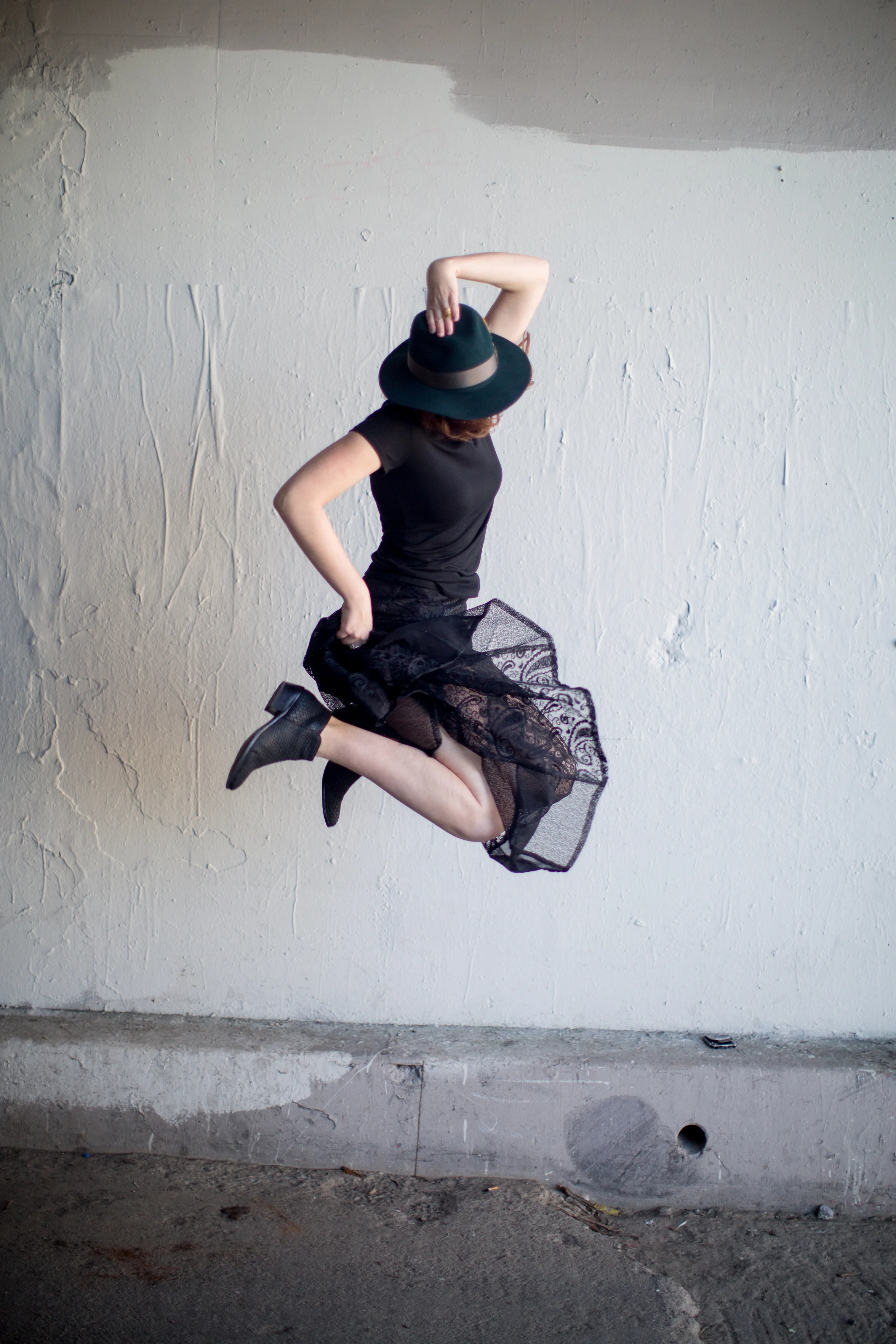 Woman in a black dress jumping against a white wall, lifestyle photography Los Angeles (Copy)