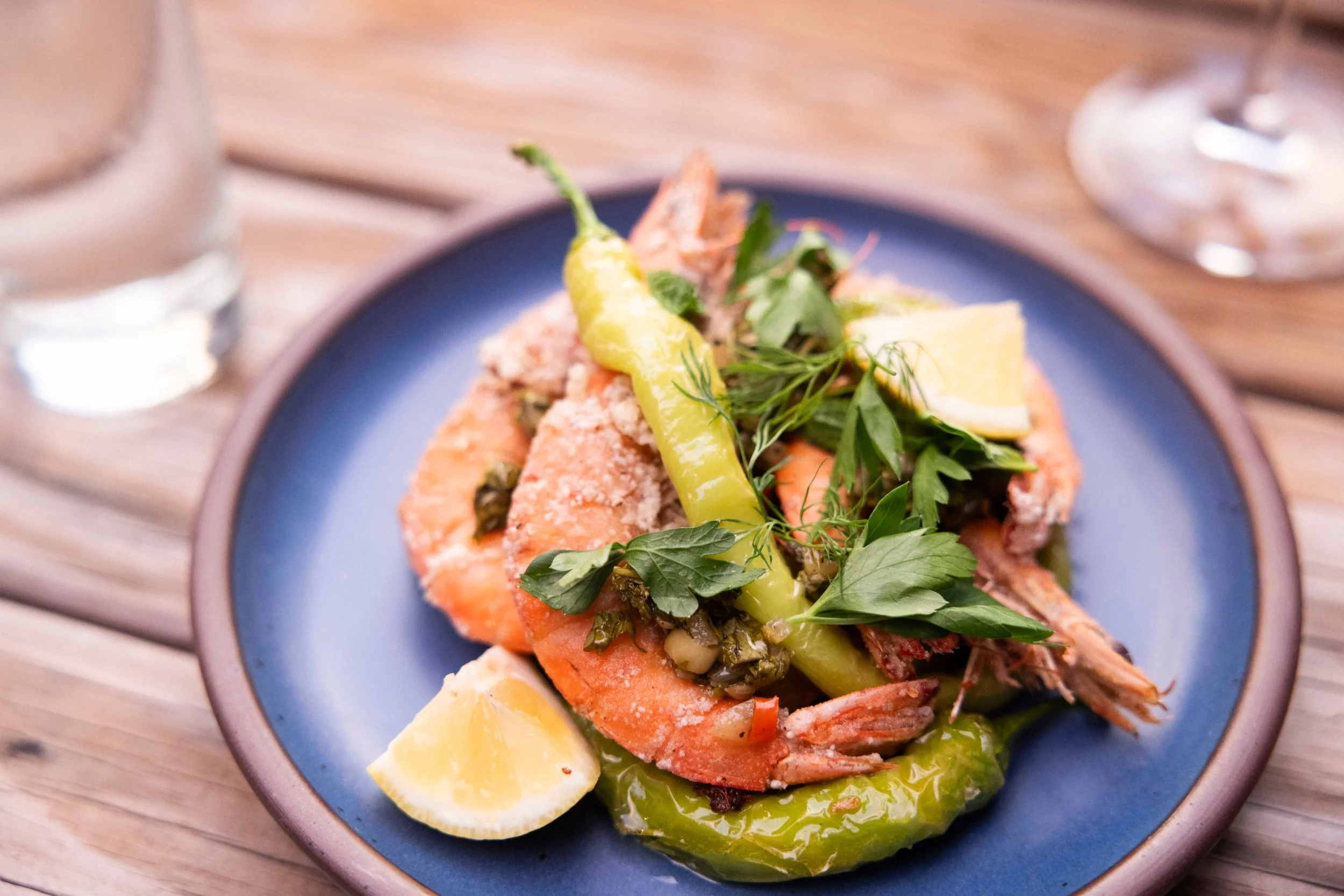 Asheville food photographer shrimp plate with green chili, herbs and lemon on a blue plate