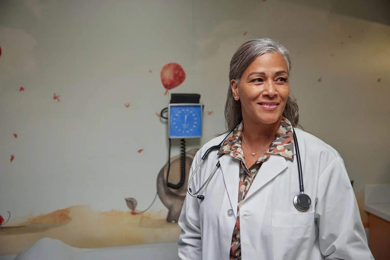 Portrait of a smiling female doctor with a stethoscope in a pediatric exam room, Beyfortus clinician photography