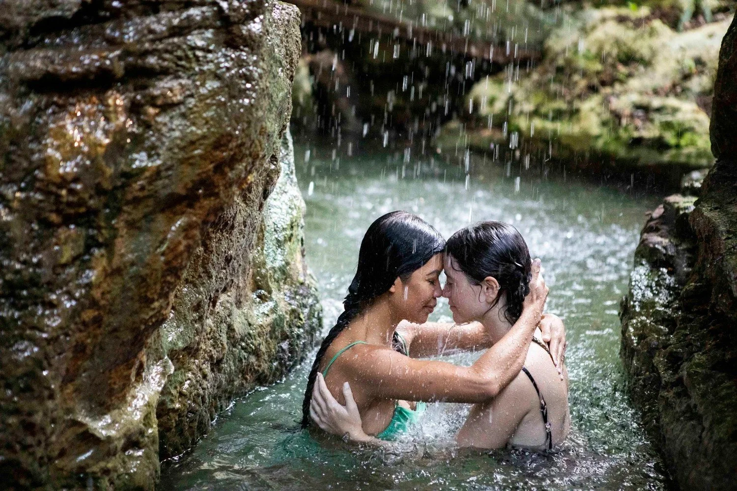 Two women touching foreheads in a mountain waterfall pool, women's retreat photography in Riviera Maya, Mexico