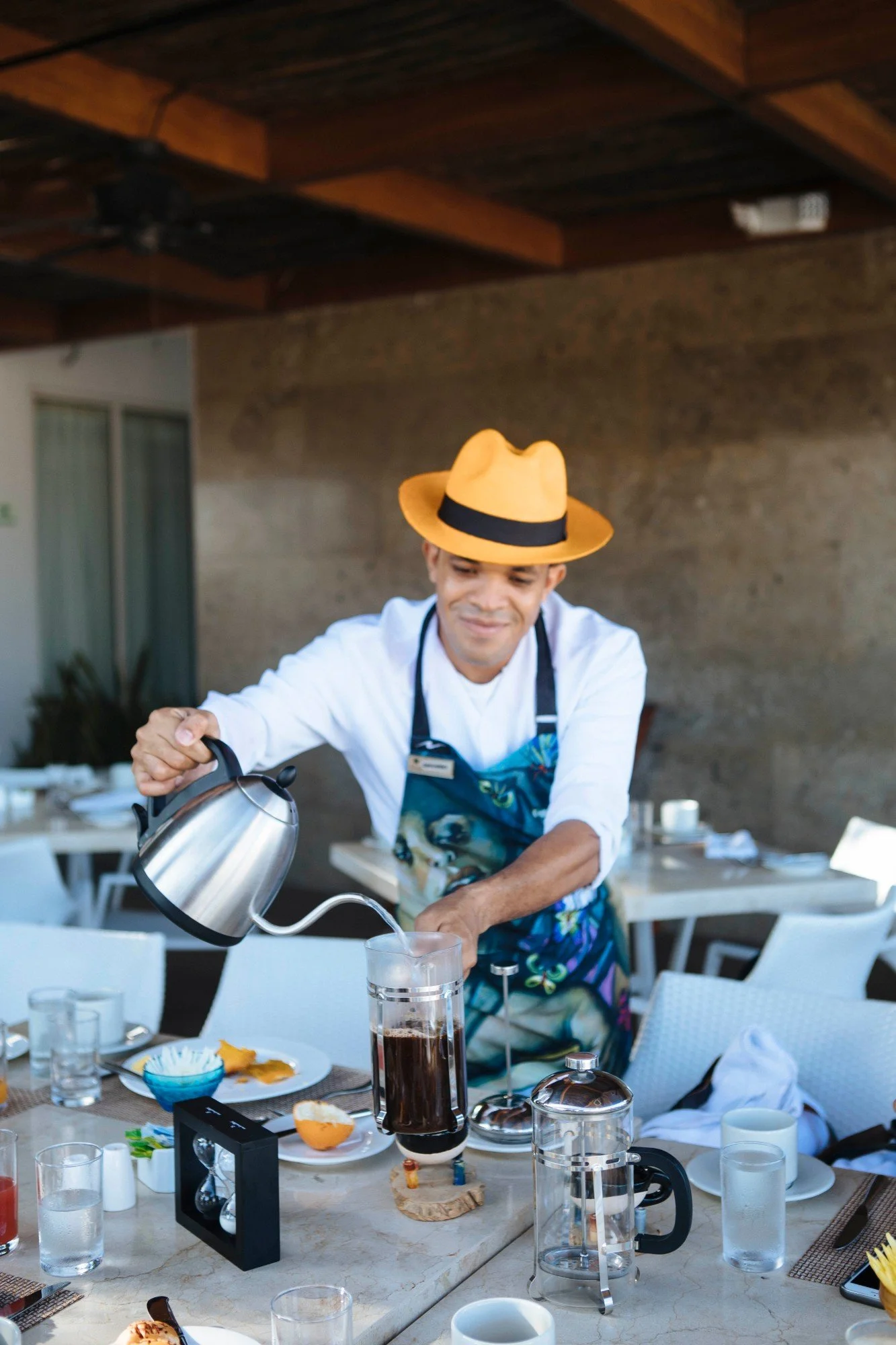 Chef in a straw hat pouring coffee at a breakfast table, travel photography in Colombia