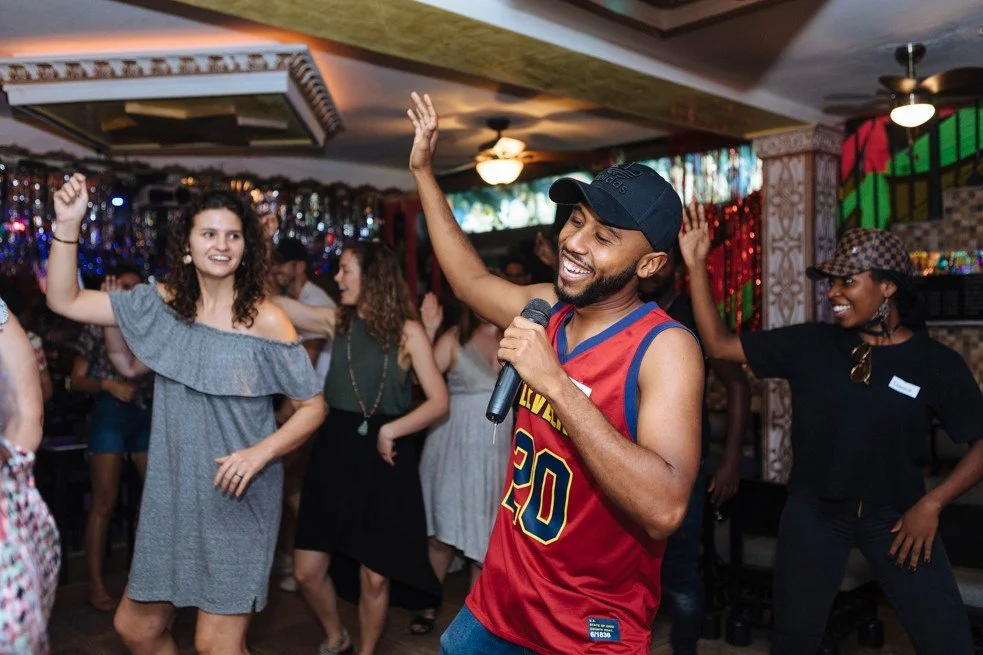 Group dancing as a singer raises his arm, travel photography in Colombia