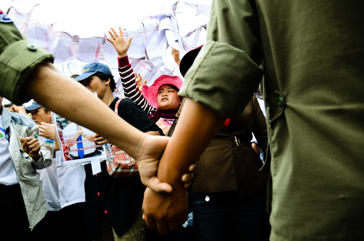 Police lock hands to block protesters from coming near a courthouse where broadcaster Mam Sonando was being sentenced to 20 years in prison.