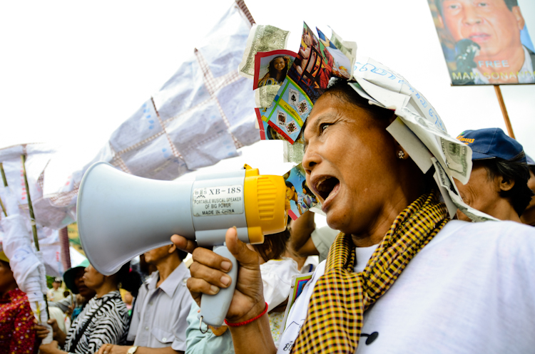 A woman shouts into a megaphone outside the Phnom Penh Municipal Court House. Supporters of jailed broadcaster Mam Sonando gathered to protest against his detention.