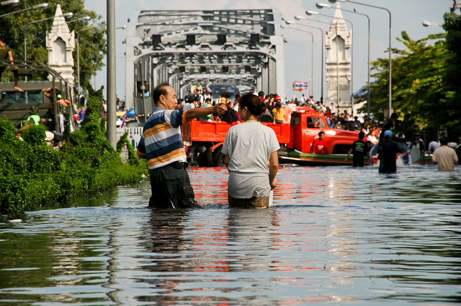  Residents leave a flooded Bangkok neighborhood. 