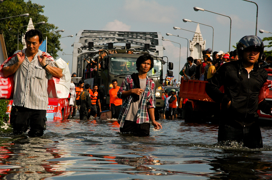  Residents bring supplies into a flooded neighborhood in western Bangkok. 