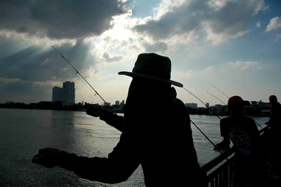  Residents fish on a bridge over Bangkok's Chao Phraya river. 