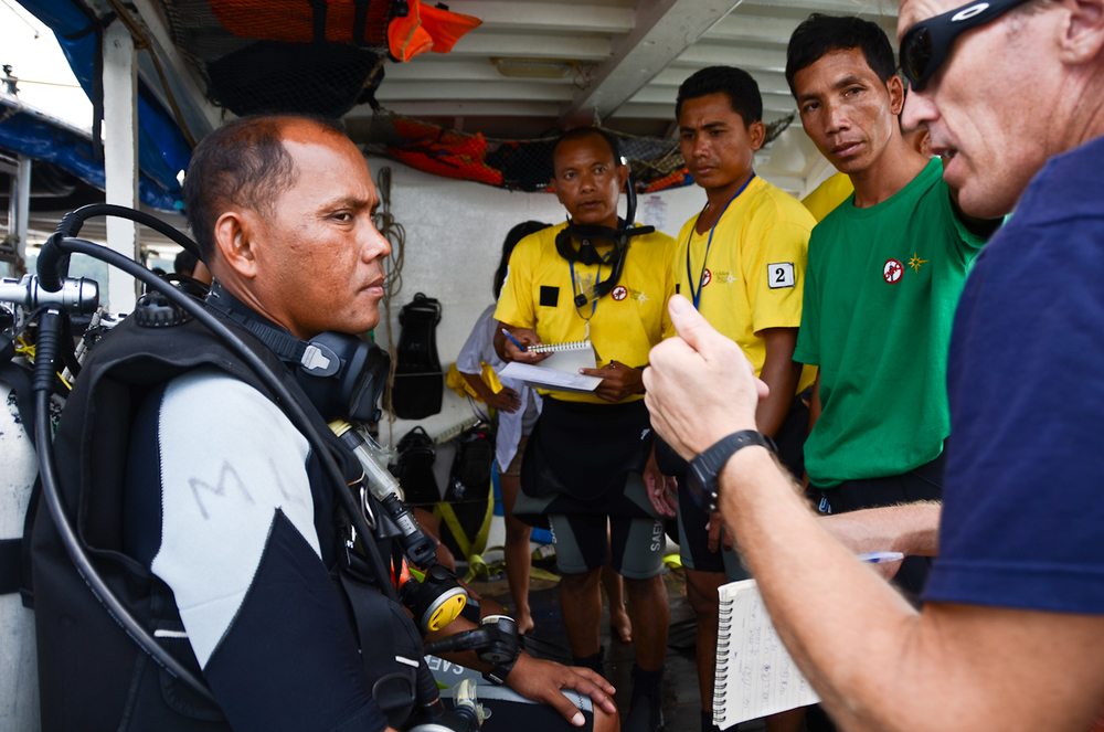  Former US Navy diver Robert Rice, right, debriefs a recruit following the completion of a mission during training for Cambodia's first underwater UXO salvage team. 