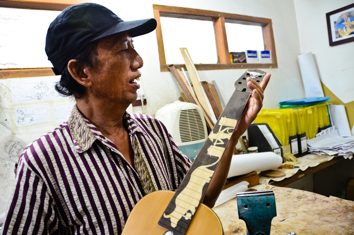  Wayan Tuges inspects a work in progress at his Bali guitar workshop. 