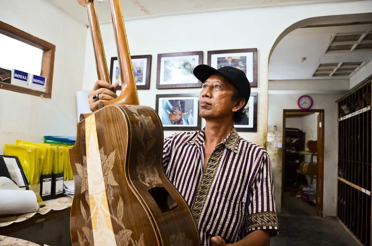 Wayan Tuges inspects an early prototype of a new guitar model: a double-necked acoustic/electric hybrid.