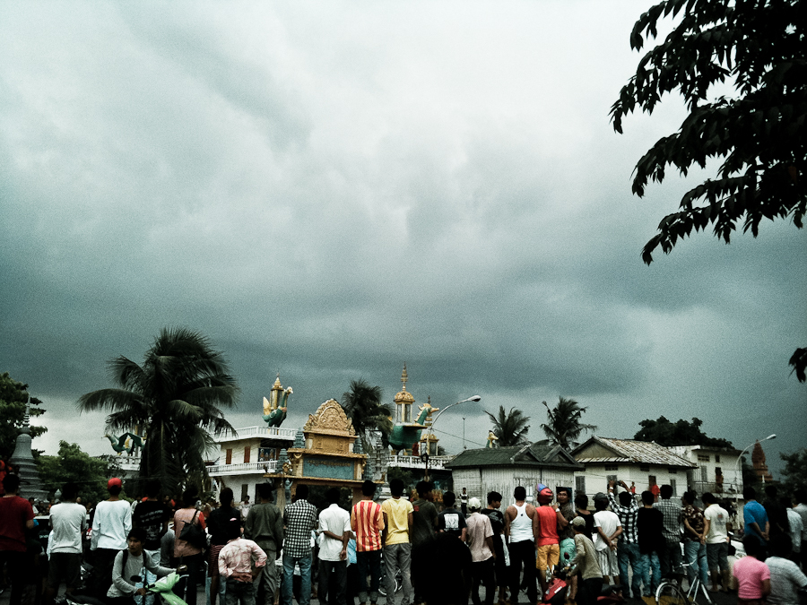  A storm cloud hovers overhead as protesters and onlookers gather outside a polling station in Phnom Penh. 