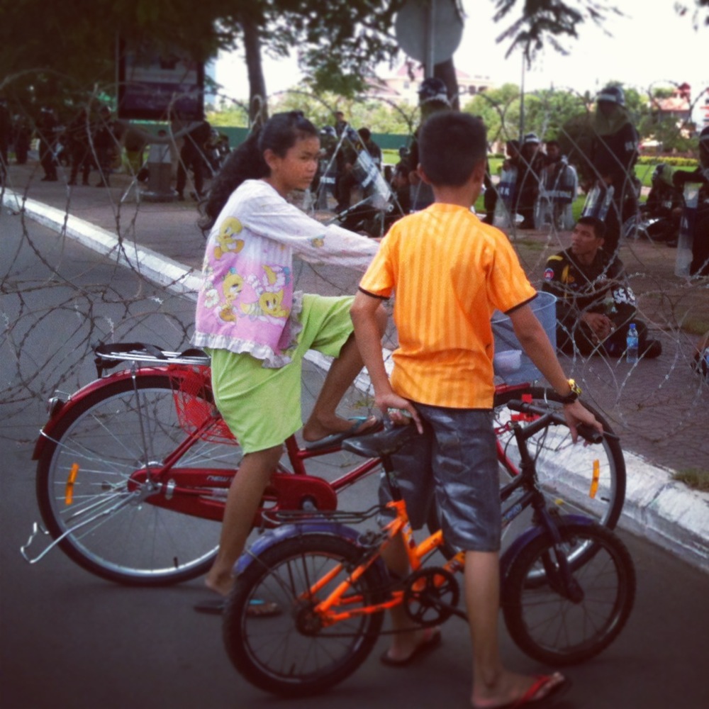  Children play by a barbed wire fence in central Phnom Penh. 