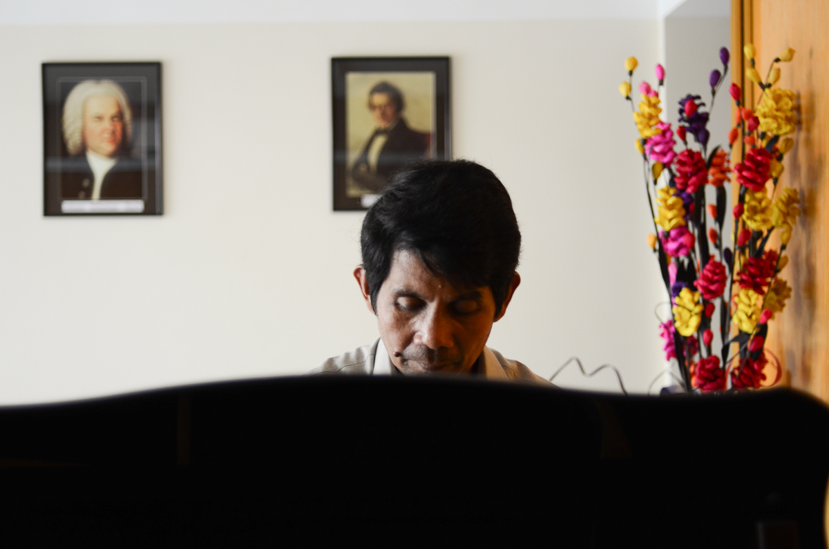 Him Sophy plays the piano at his studio in Phnom Penh.