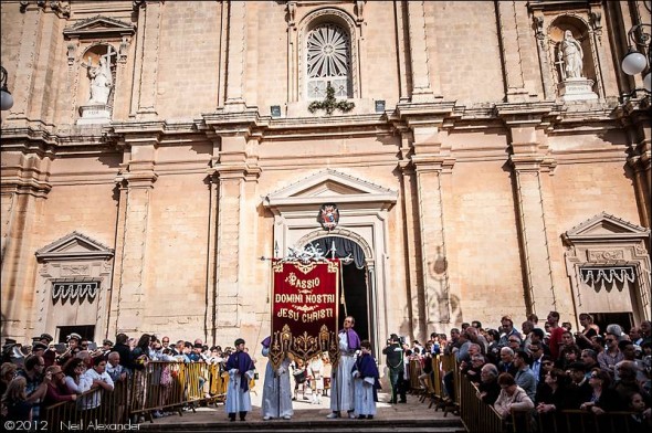 The Passion of Our Lord Jesus Christ banner leaving St. Catherines church as part of the Good Friday parade Zejtun Malta complete with TV cameraman
