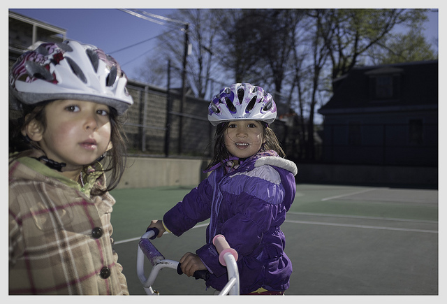 Here, and in the same harsh direct sunlight, the photographer has used on-camera fill flash to put light into the shadows caused by the girls' helmets onto their face. Image courtesy of Soe Lin