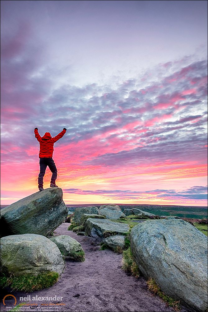 A lone hiker at sunrise over Higger Tor in the Peak District