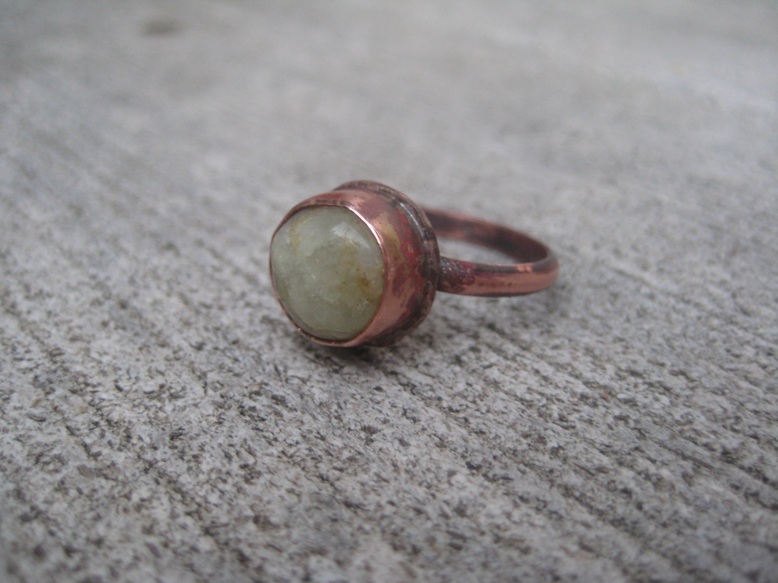 My FIRST attempt ever at a bezel setting. Far from perfect, but functional! ;) A bezel is basically a band of metal that encompasses an object (in my case, a gemstone) which is then soldered to a piece of metal that is part of the jewelry piece. It essentially makes a shallow “cup” that the gem sits in, and then the top of the bezel is rubbed over or burnished over the edge of the gem. This burnishing thins and smooths the bezel edge and holds the gem into place.