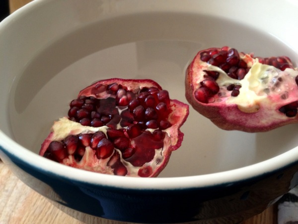 halved pomegranate on its way to being quartered