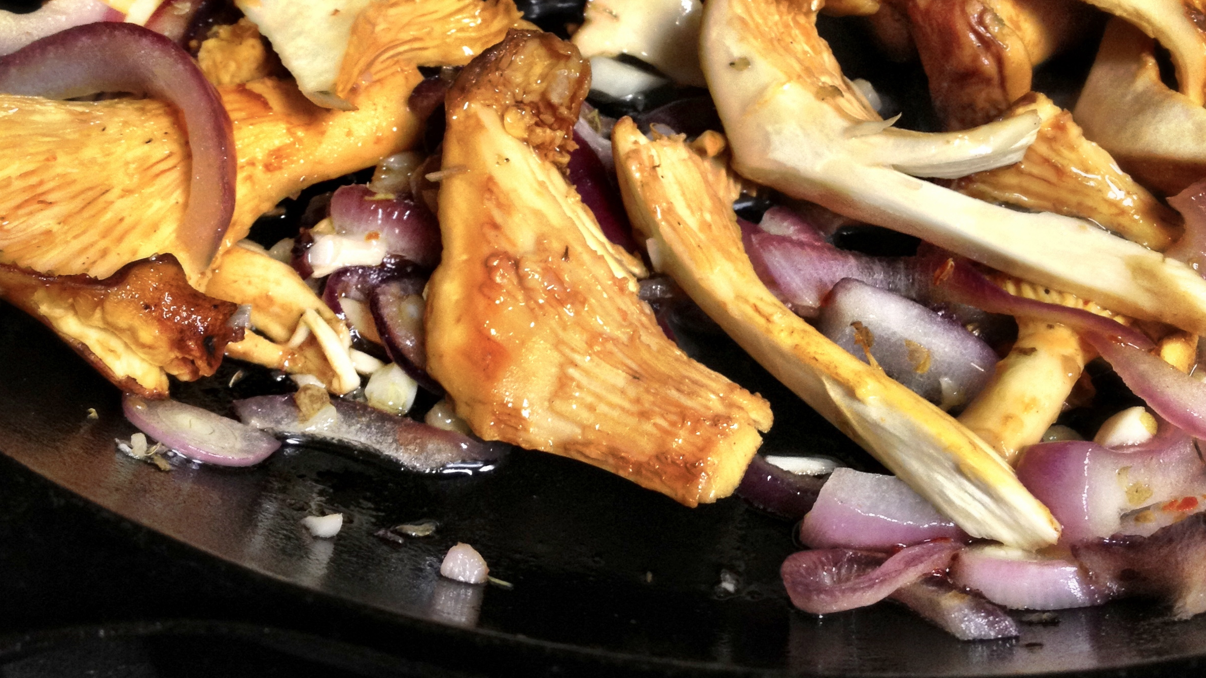 chanterelles, red onions, garlic in a cast iron pan