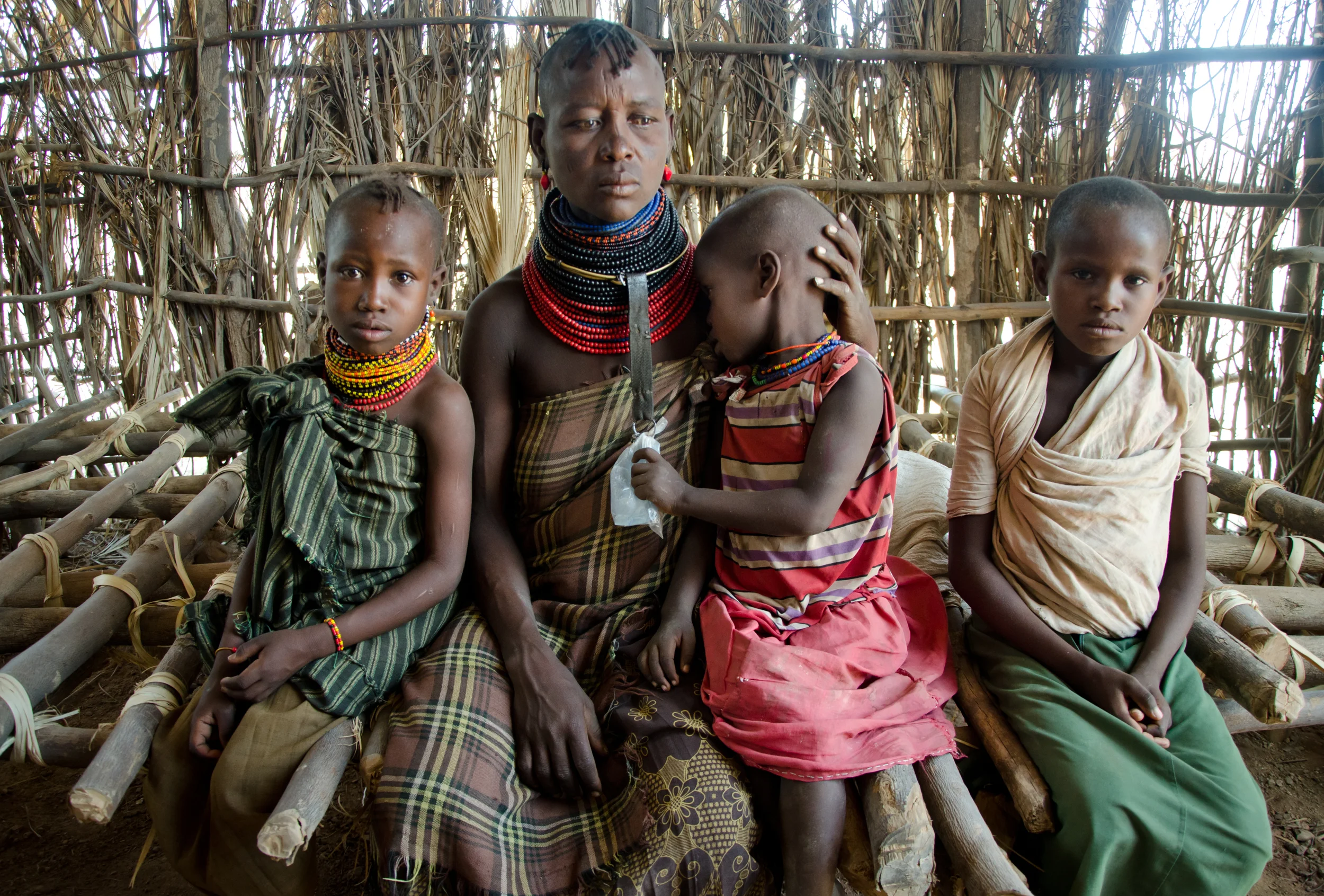  ​Emuria, 39, at a food distribution with three of her five children in Turkana, Kenya. Emuria's husband was shot in a cattle raid a little more than two years ago, leaving her to provide for the children on her own. All of their camels, cows, and go