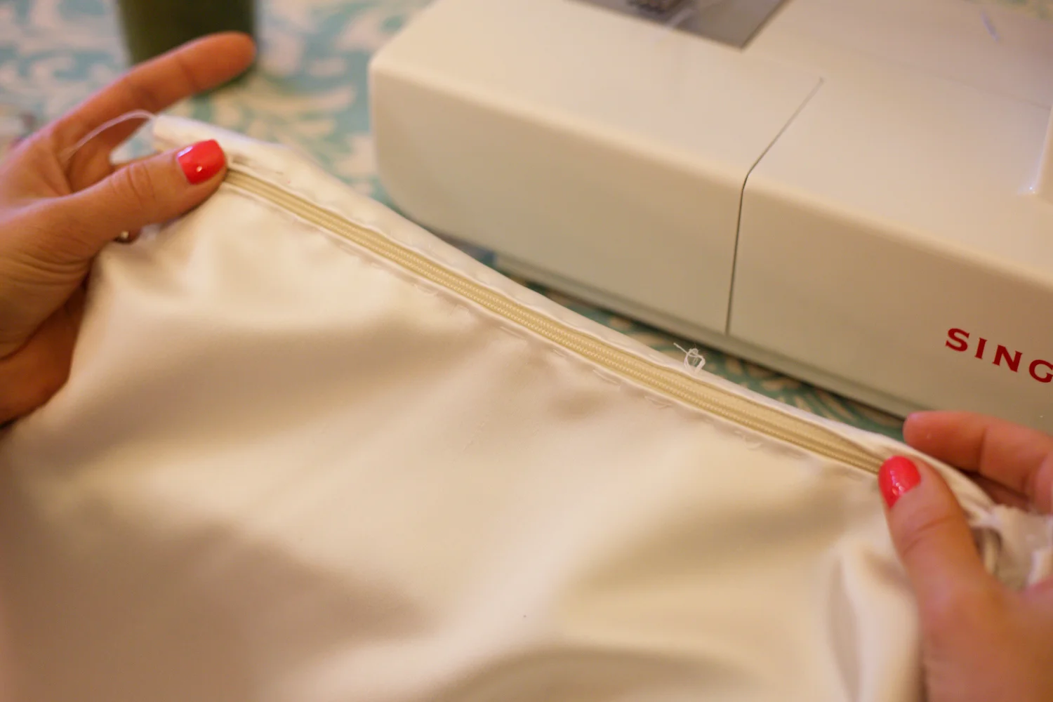 Stitch by hand to keep the zip in place when you sew it with the sewing machine