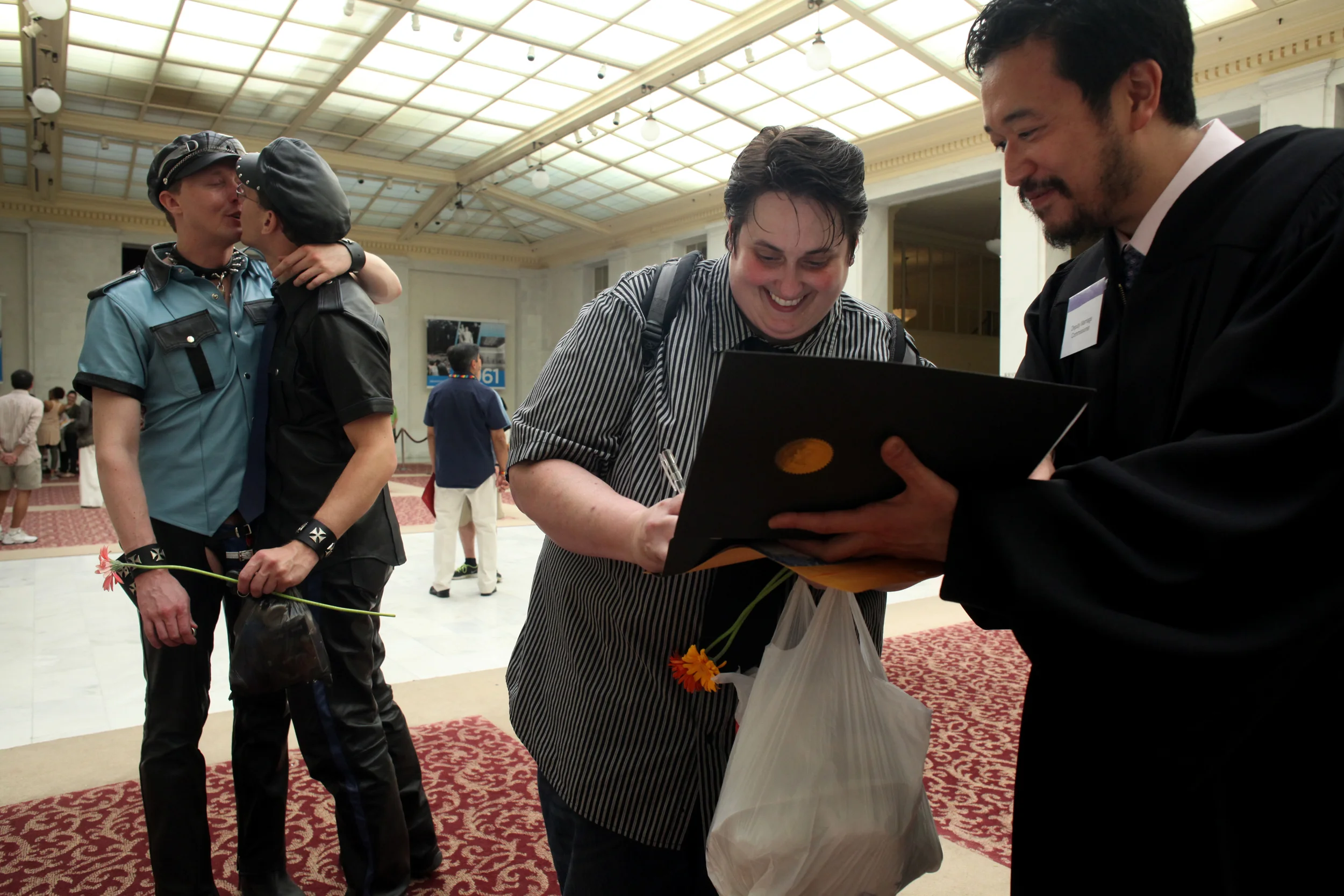 Following the parade I headed to City Hall where they had extended their hours allowing for same-sex partners to be legally married over the weekend. Marlene Gallo signs as a witness following the wedding of Matthew Pfeuffer and Michael Stoops.