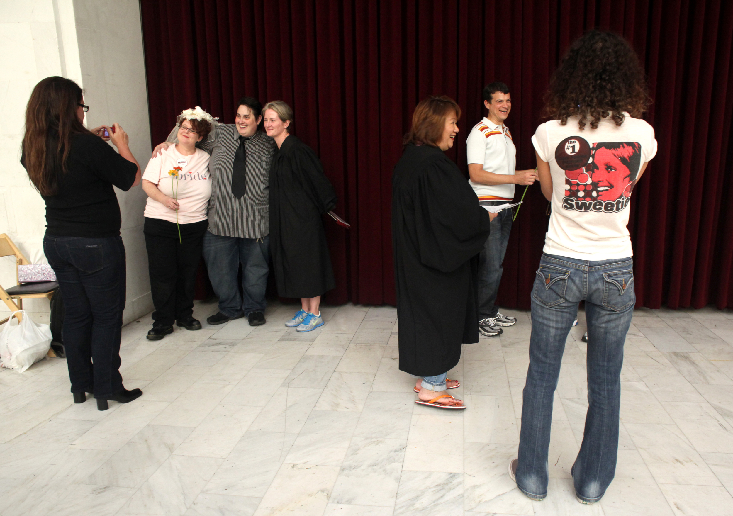 The scene at City Hall was multiple couples getting married simultaneously wherever they could find floor space to stand and face each other. There were many Deputy Marriage Commissioners, dressed in black robes, spaced around the room waiting to declare "spouses for life."