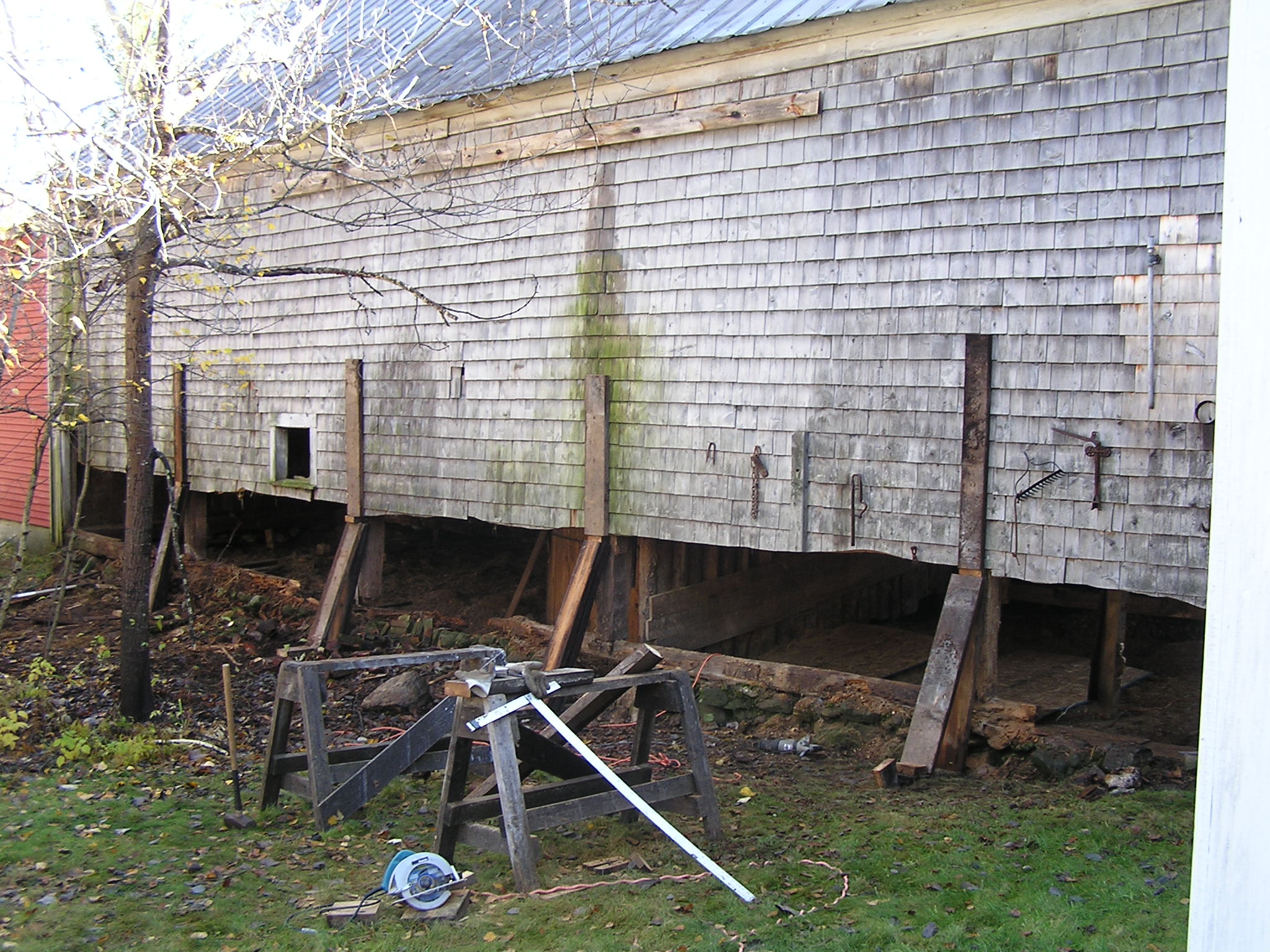 Here the entire side of a barn is jacked up and held with temporary posts. The next step is to pour a new foundation and slide into place a new 8' x 8'  sill.