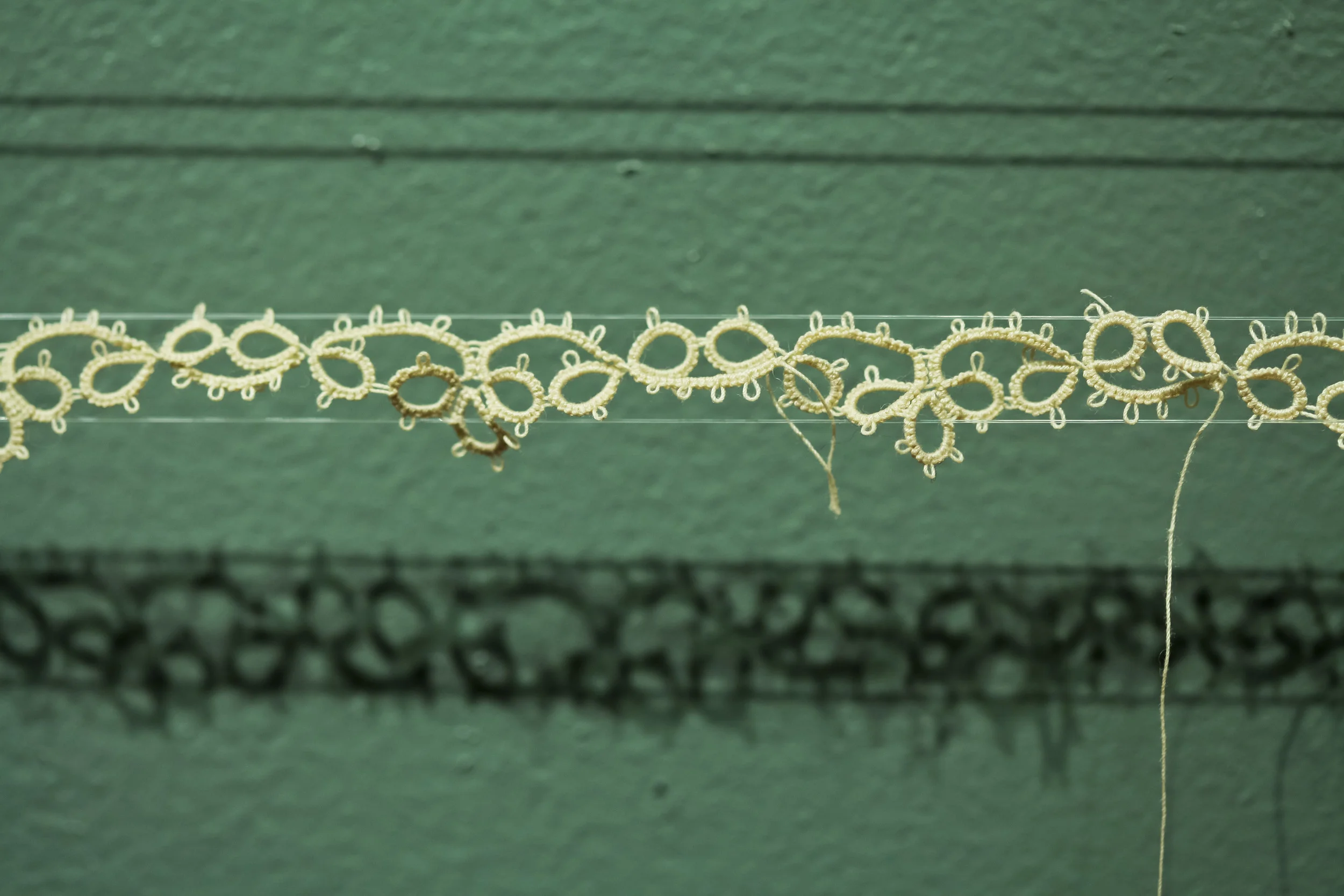 Untitled cotton thread, nylon thread 2012 text reads, "I had a spot on the hoizon between two scrappy clumps of trees | I didn't want it. I tore it out. It left behind stray scraps in the coil binding."