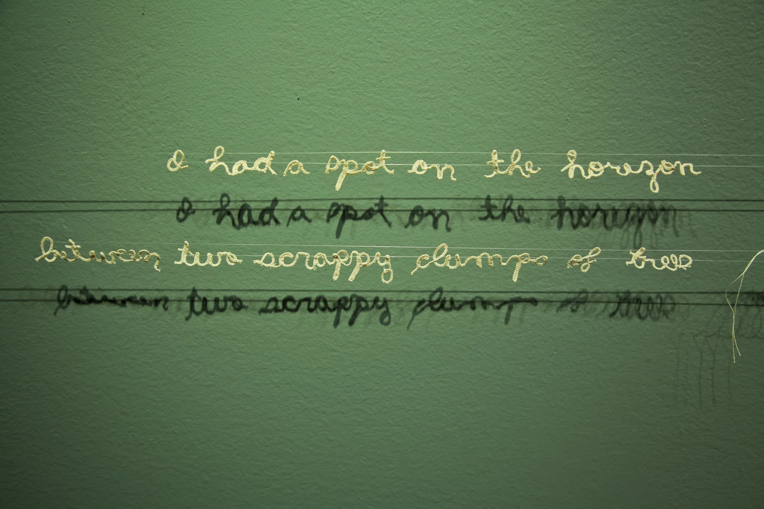 Untitled cotton thread, nylon thread 2012 text reads, "I had a spot on the hoizon between two scrappy clumps of trees | I didn't want it. I tore it out. It left behind stray scraps in the coil binding."
