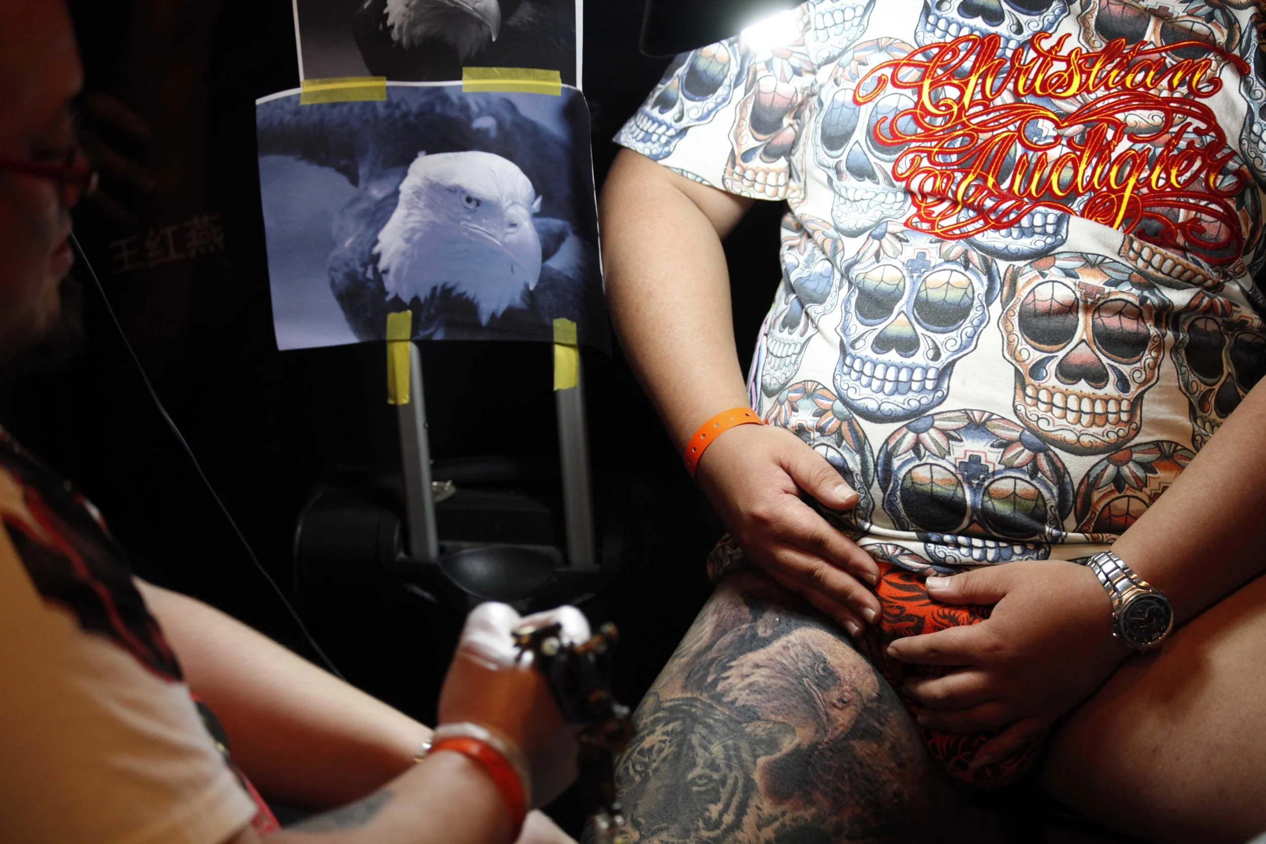  A man gets an eagle tattooed on his thigh during a tattoo demo at an electronic music festival in Beijing's 798 Art District, in May 2012.  