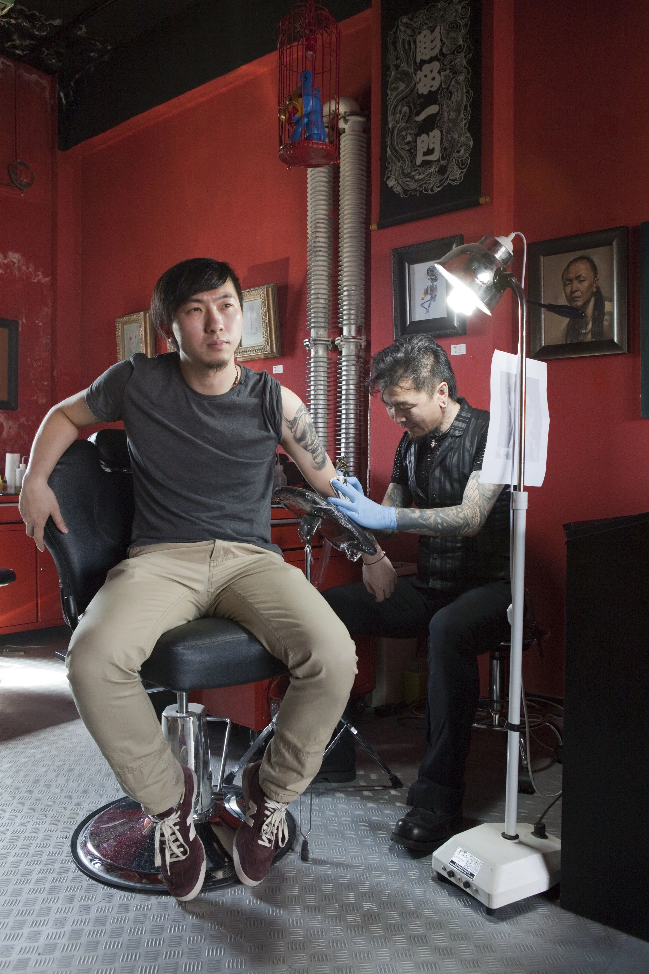  Xiao Long of Long Xiu Tang tattoo studio in Beijing's 798 Art District works on his own apprentice's arm. Photo for a July 2012 piece for City Weekend. 