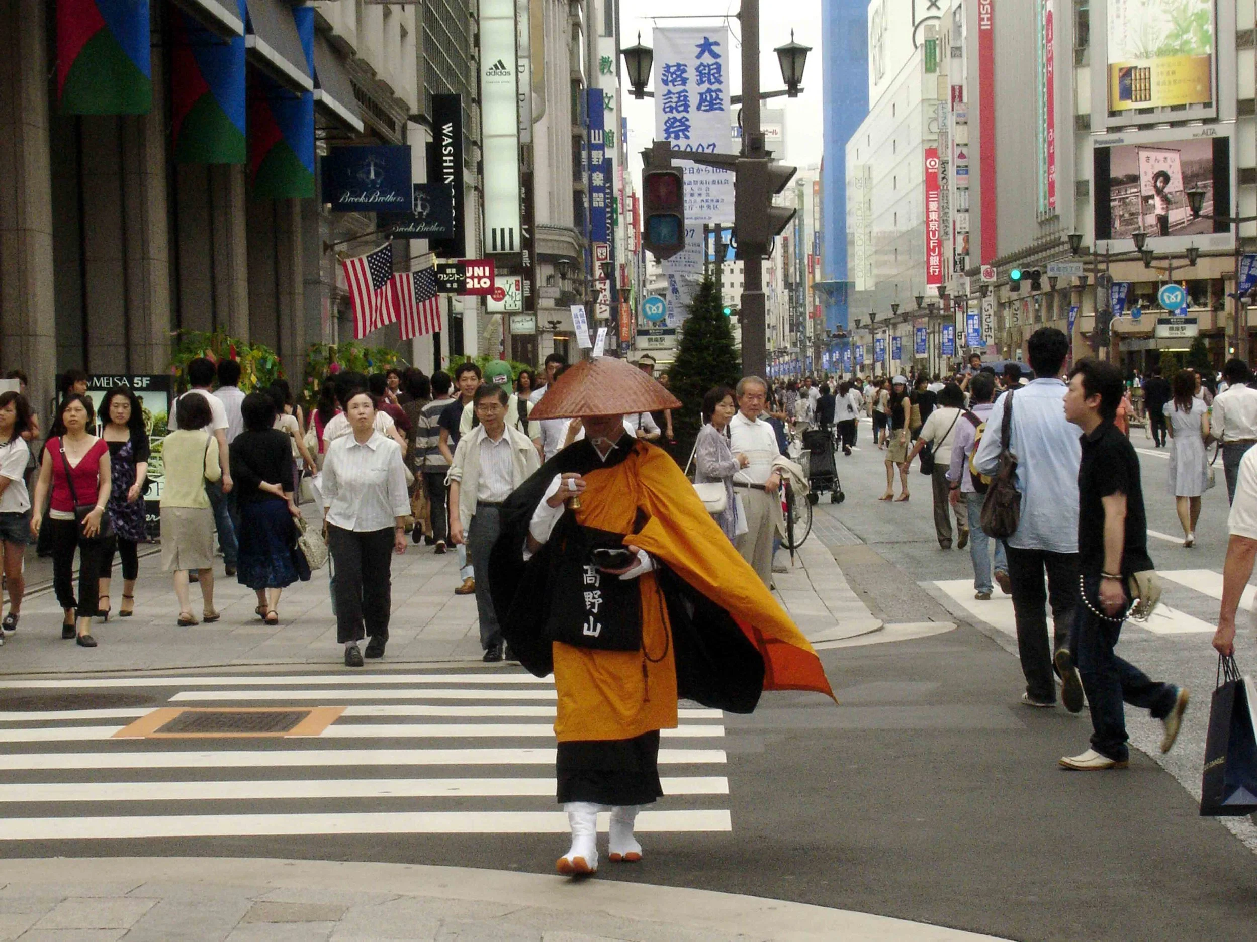  A monk passes through the crowds of shoppers in bustling downtown Tokyo. 