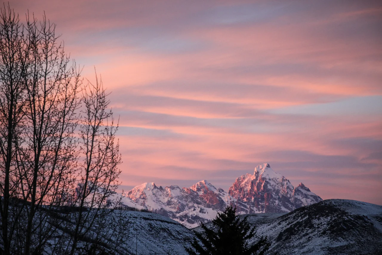 The sunset glows on the Teton Mountains as another day concludes in Jackson Hole, Wyoming, USA. 
